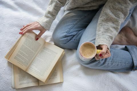 Жена у кревету са кафом и књигом