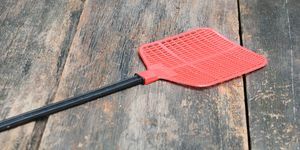 црвена мушилица једнострука мушилица направљена од пластике и непогрешива у хватању мува на позадини дрвеног пода