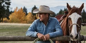 Кевин Костнер у жутоустону поред коња наслоњеног на ограду са конопцем у рукама, који носи избледелу плаву тексас кошуљу и беж каубојски шешир