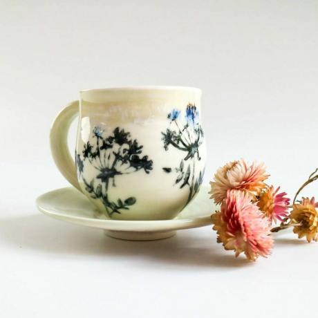 Порцеланска шоља и тањир у дизајну цвећа за живу ограду