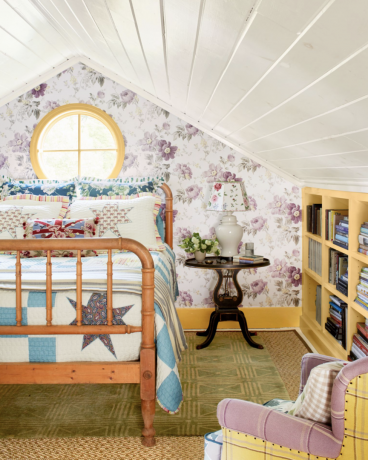 шармантна сеоска спаваћа соба са дрвеним креветом и светло љубичастим цхинтз тапетама