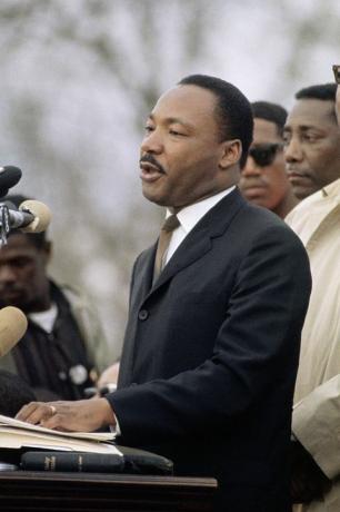 Лидер за грађанска права др Мартин Лутер Кинг на подијуму држи говор у Монтгомерију, Алабама, после марша за грађанска права Селма у Монтгомери